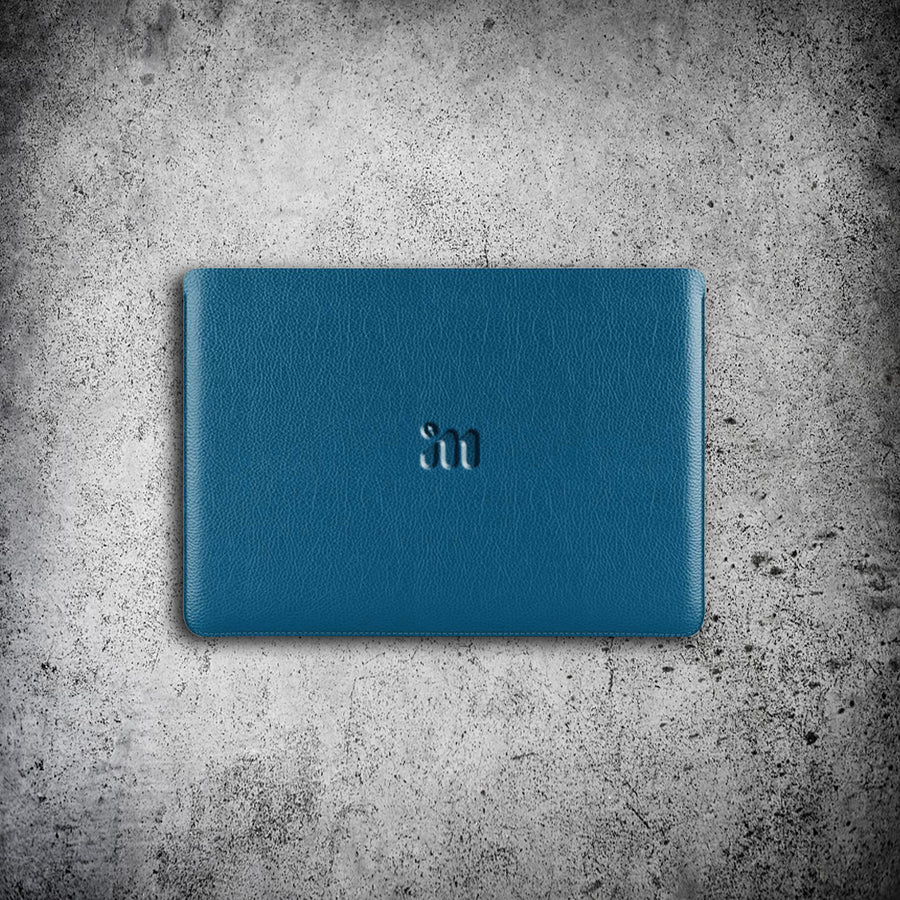 IM™ Luxurious deep blue/teal Nappa leather MacBook Air 13 sleeve with embossed "I M" logo, top view.
