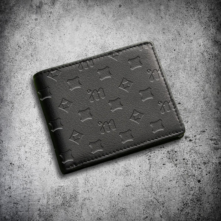 IM™ Luxurious black Halal cow leather bifold wallet with all-over debossed IM monogram pattern, angled top view.

